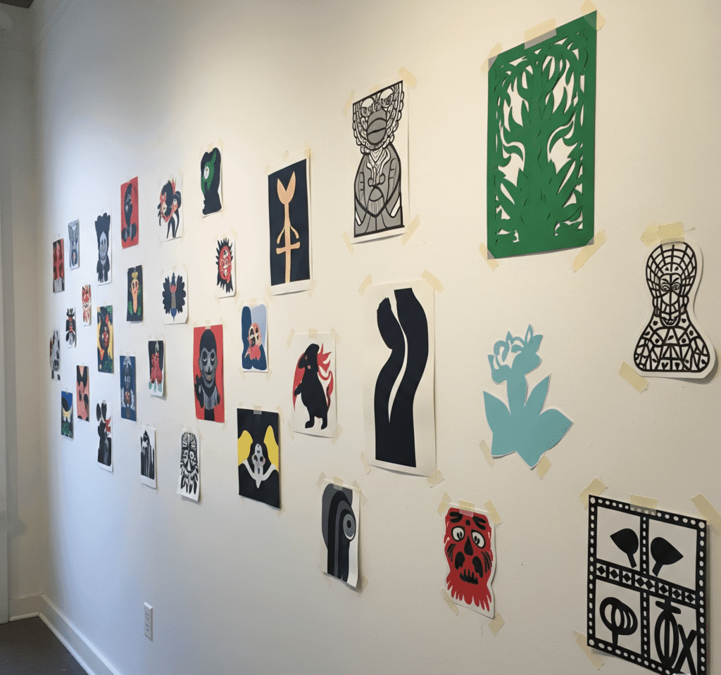 The Best Art for Small Spaces: Tips and Ideas 5 Paper cutouts taped to a wall, testing a gallery layout before hanging frames