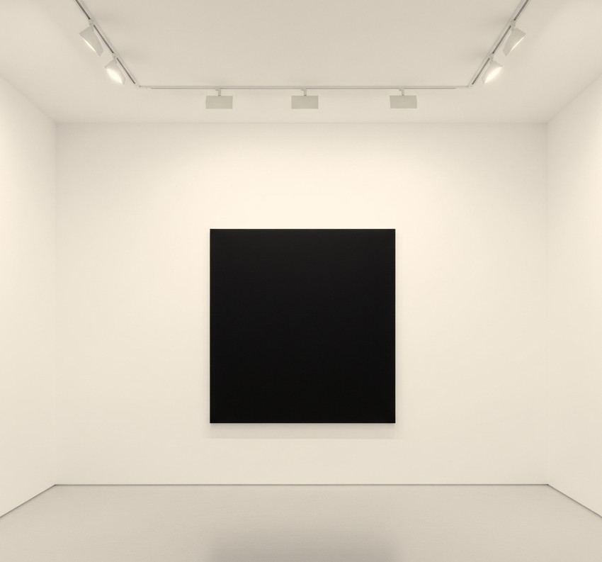 Exploring Minimalism: A Global Trend in Modern Art 2 A white-walled gallery with a single large black square canvas hanging in the center